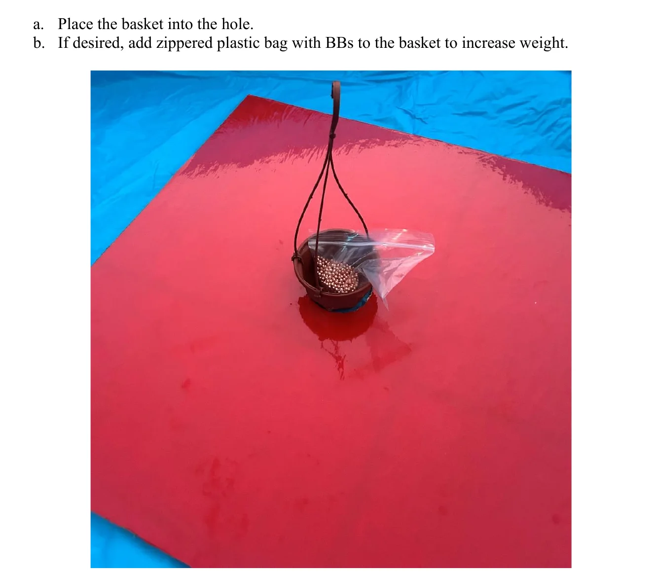 Figure 2.10 Add Basket and BBs. a. Place the basket into the hole. b. If desired, add zippered plastic bag with BBs to the basket to increase weight.